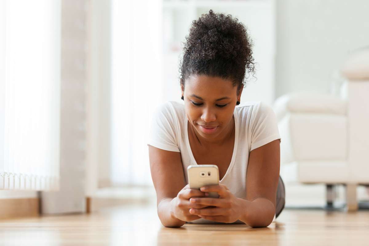 African American woman sending a text message on a mobile phone (R) (S)