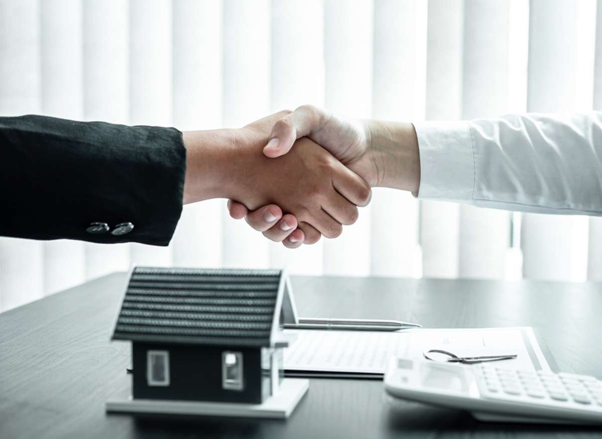 Estate agent and client are shaking hands (R) (S)