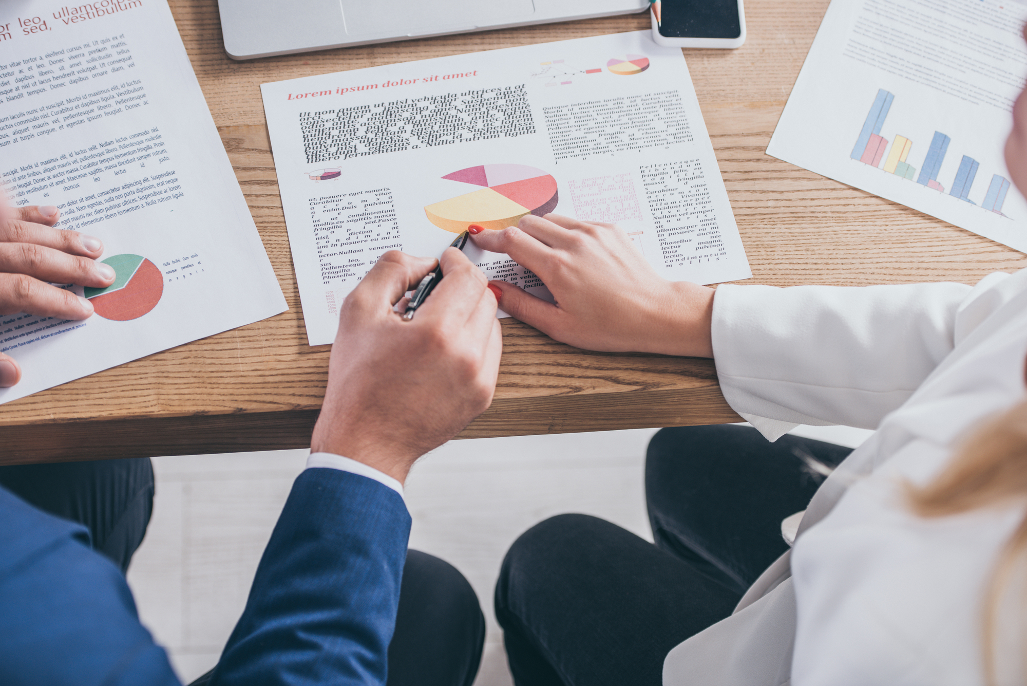 Partial view of two risk managers analyzing infographics together