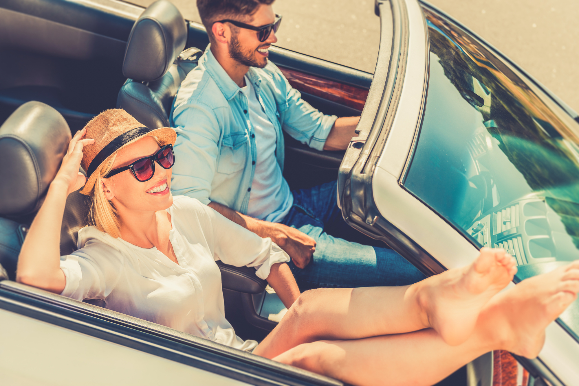 Woman and her boyfriend driving their convertible