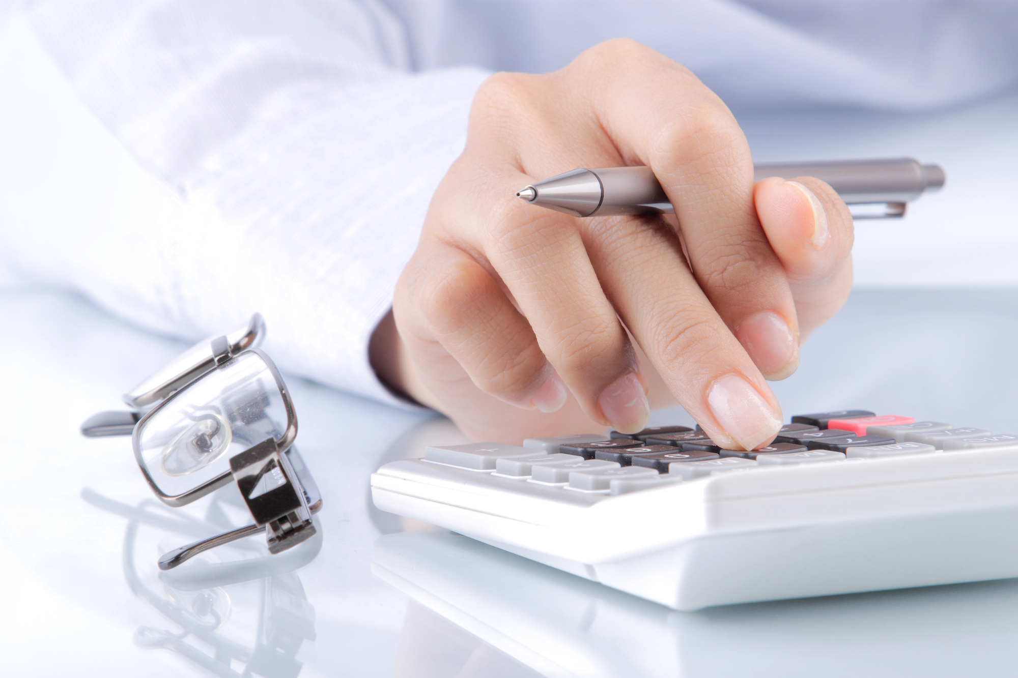 Womans hands with a calculator and a pen